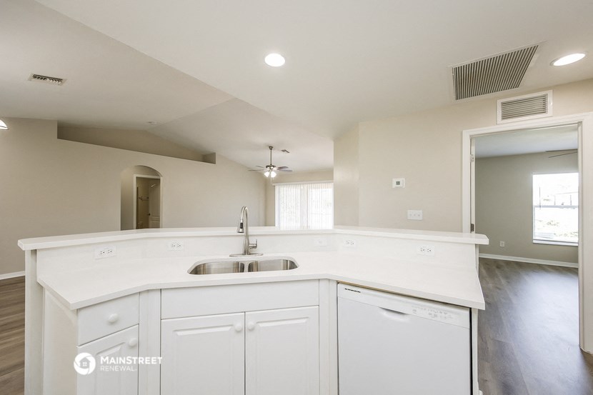 an empty kitchen with white cabinets and a sink