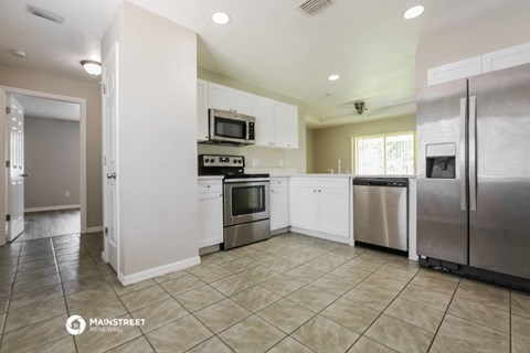 a large kitchen with stainless steel appliances and white cabinets