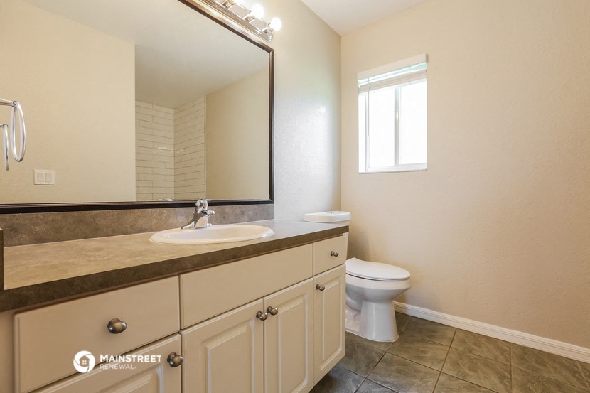 a bathroom with a toilet and a sink and a mirror
