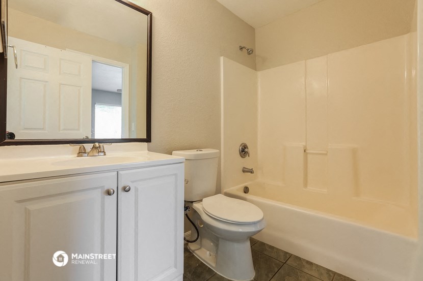 a bathroom with a toilet and a tub and a sink