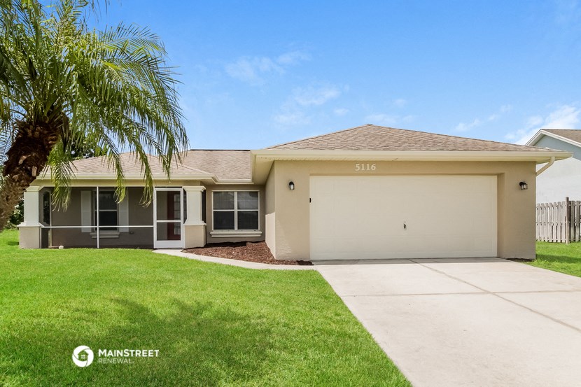 a beige house with a palm tree in front of it