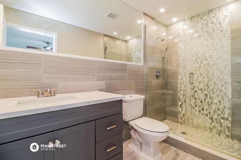 a bathroom with a toilet and a shower and a sink