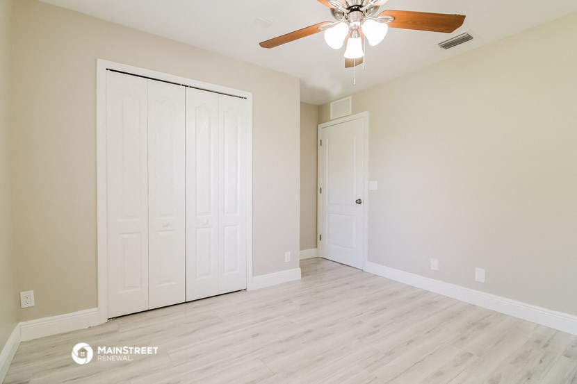 the living room of a new home with a ceiling fan