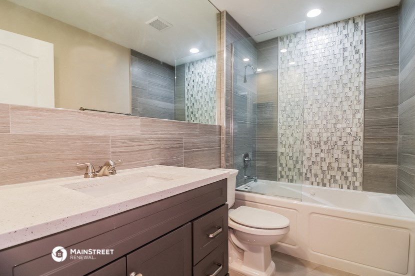a bathroom with a toilet and a tub and a sink