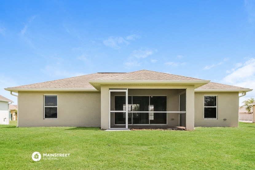 a beige house with a lawn in front of it