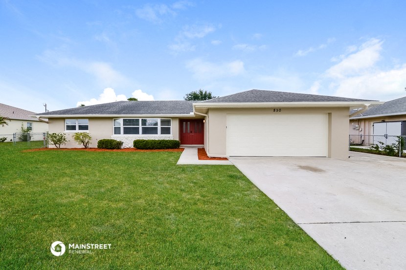a white house with a lawn and a driveway