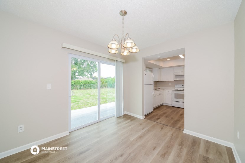 a living room and kitchen with a sliding glass door