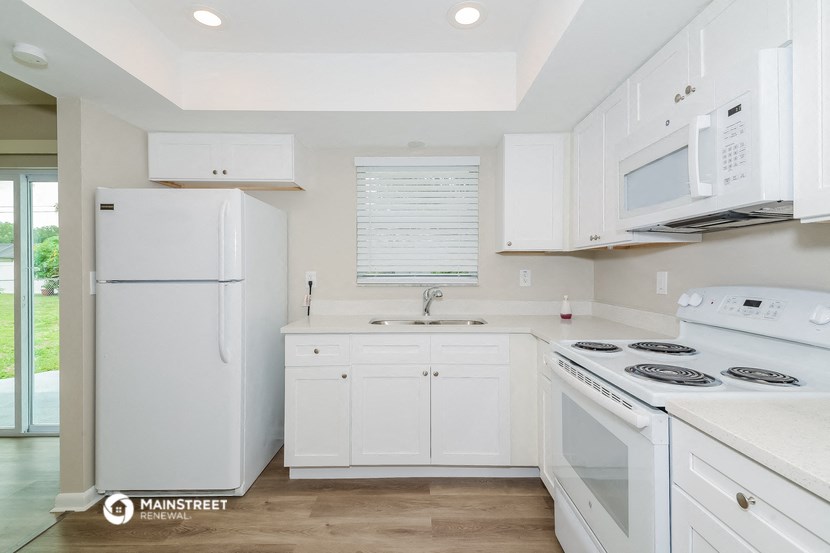 a white kitchen with white appliances and white cabinets