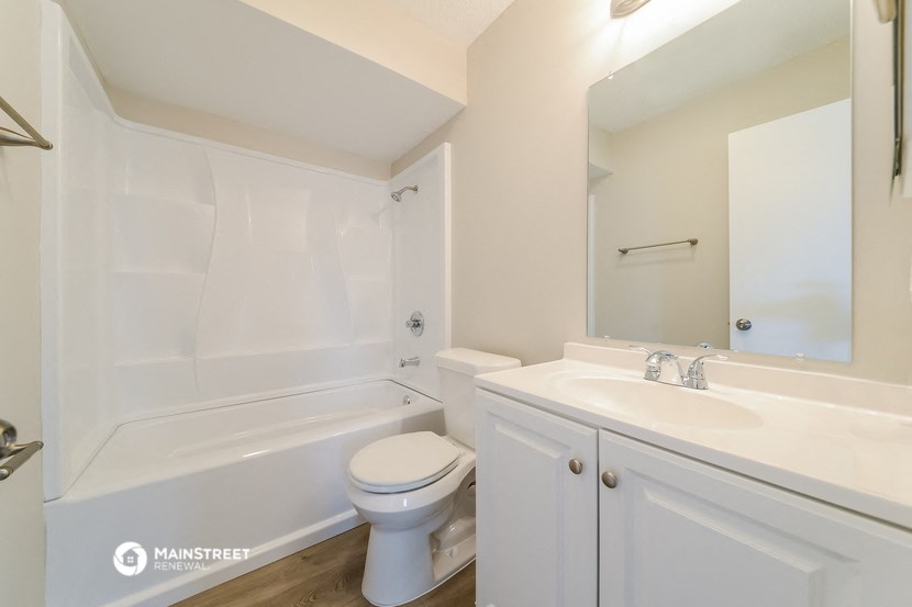 a bathroom with a sink toilet and tub and a mirror