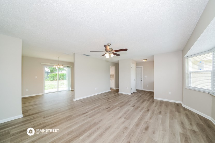 the living room and dining room with wood flooring and ceiling fan