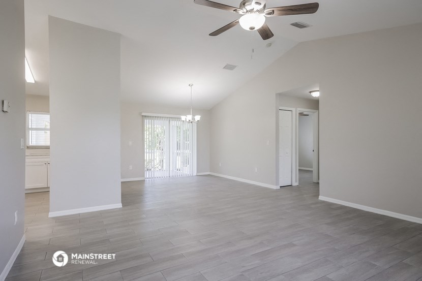 the spacious living room with a ceiling fan in a new home