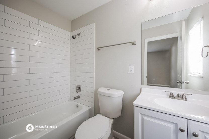 a white bathroom with a tub and a toilet and a sink