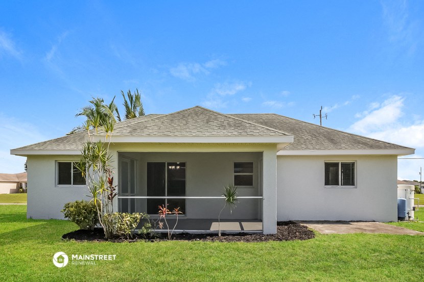 a white house with a palm tree in front of it