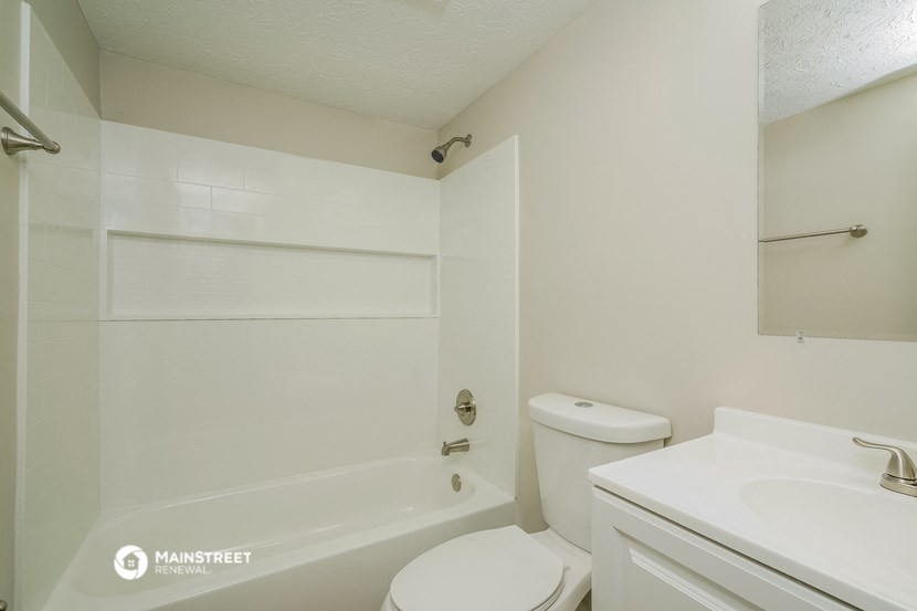 a bathroom with a toilet and a tub and a sink