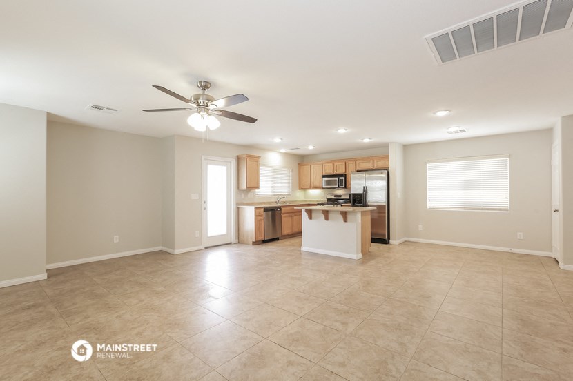 an open kitchen and living room with a ceiling fan