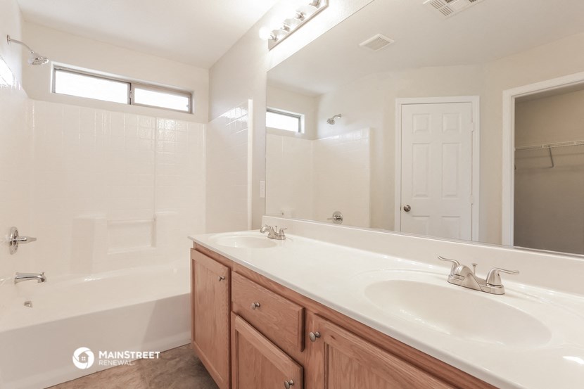 a bathroom with two sinks and a shower and a mirror