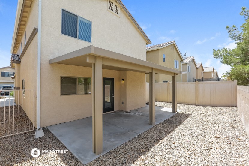 the backyard of a house with a patio and a fence