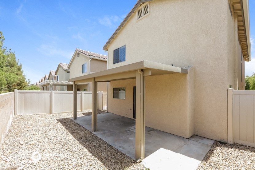 the backyard of a house with a patio and a fence