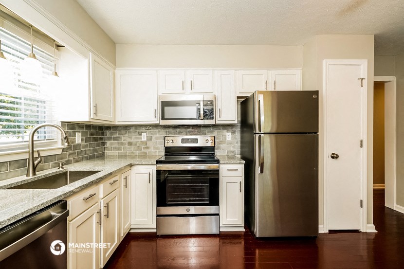 a kitchen with stainless steel appliances and white cabinets