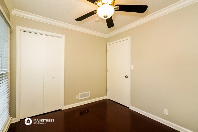 a empty room with a ceiling fan and two doors