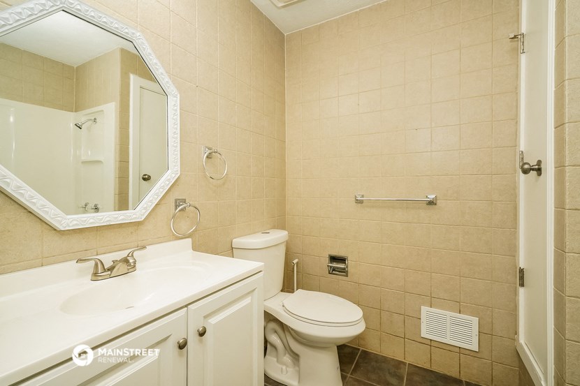 a bathroom with a toilet and a sink and a mirror