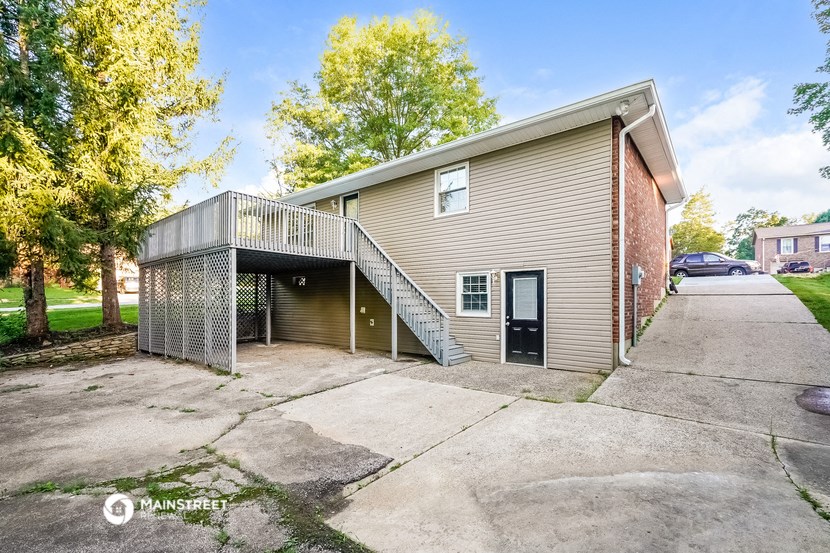 the driveway of an apartment building with a staircase on the side