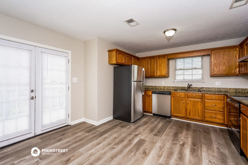 a kitchen with wooden cabinets and a stainless steel refrigerator