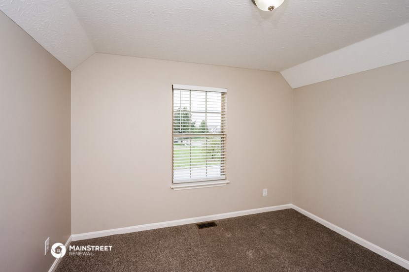an empty room with carpet and a window