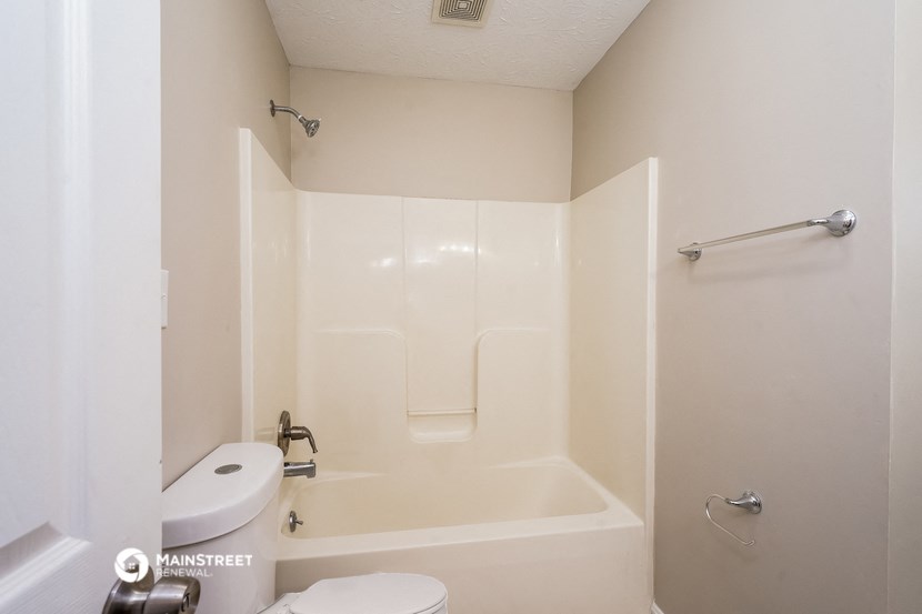 a bathroom with a toilet and a tub and a sink