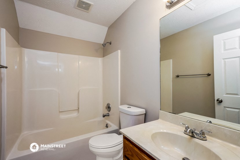 a bathroom with a shower toilet and sink and a mirror