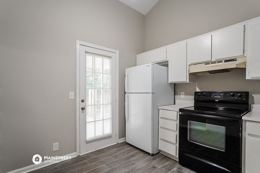 a kitchen with a stove and refrigerator and a door