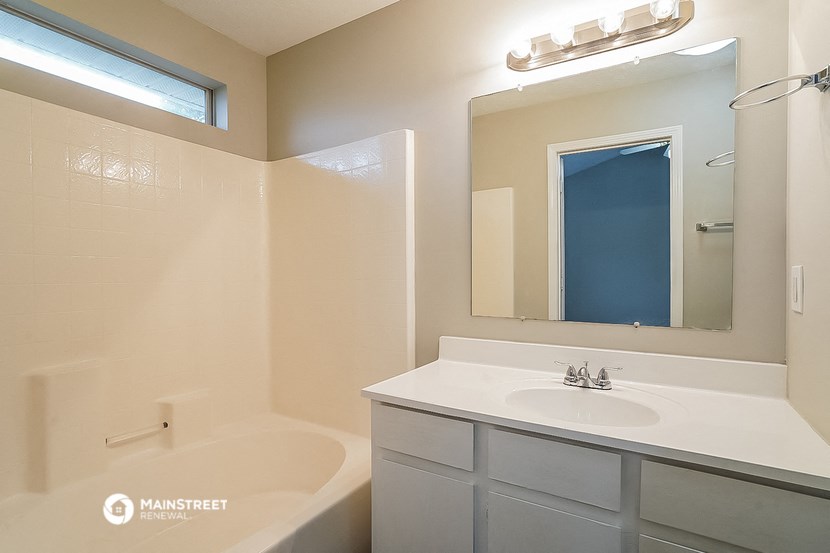 a bathroom with a sink and a tub and a mirror