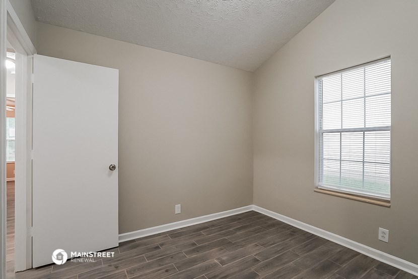 an empty room with a door and a window