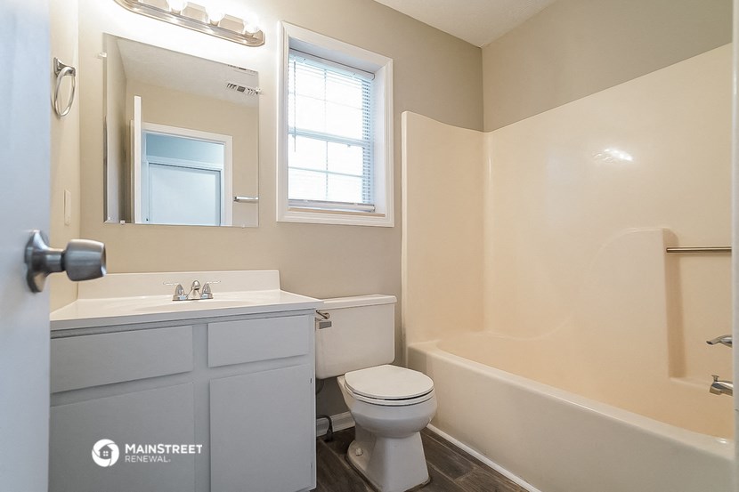 a bathroom with a toilet and a sink and a bath tub