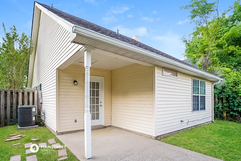 a small white house with a porch and a driveway
