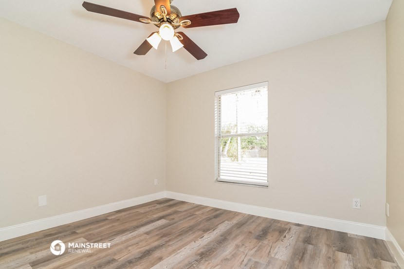 the living room of an empty house with a ceiling fan