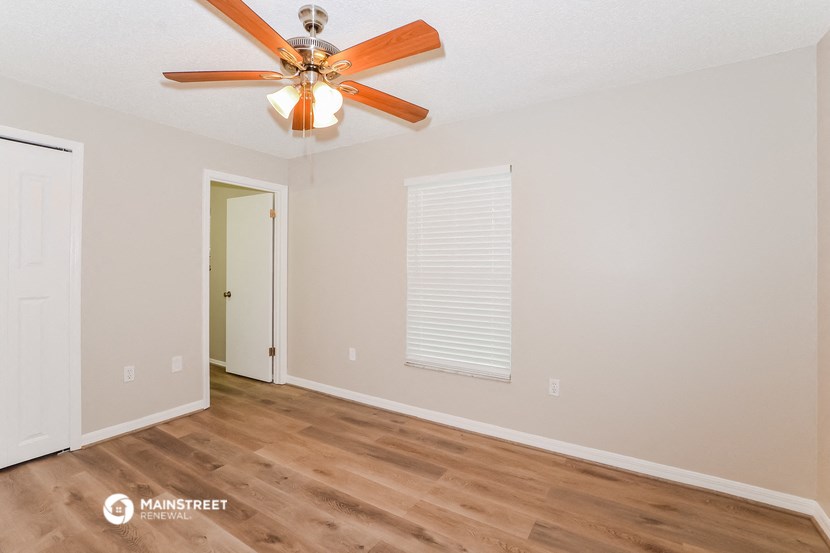 the living room of our two bedroom apartment atrium with ceiling fan and window