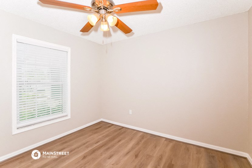 a bedroom with a ceiling fan and a window
