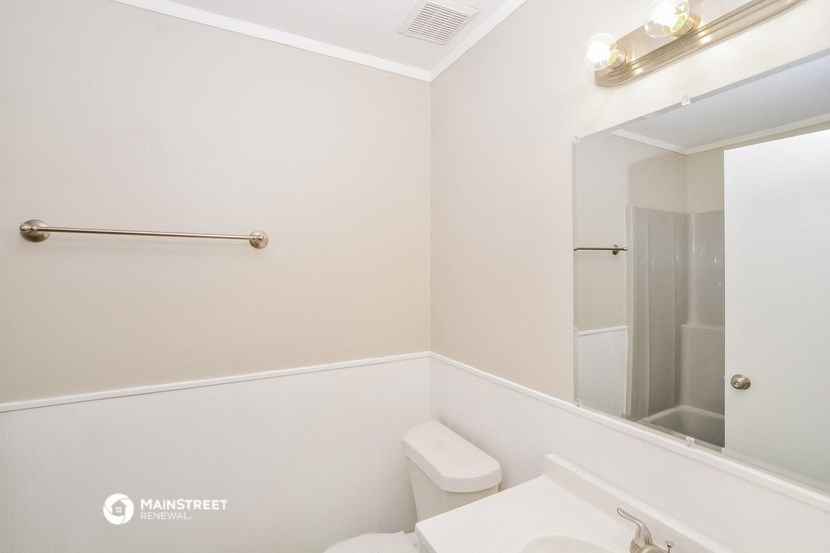 a bathroom with a toilet and a sink and a mirror