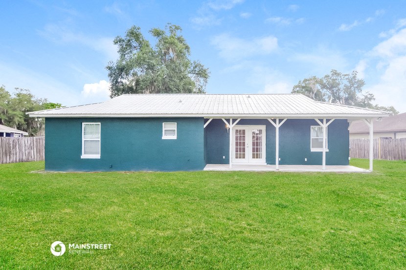 a blue house with a grassy yard and a fence