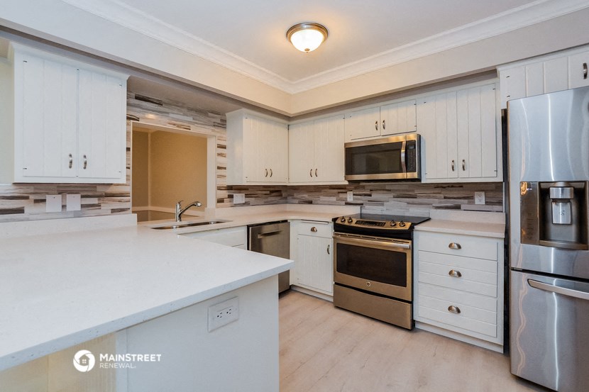 a kitchen with white cabinets and stainless steel appliances