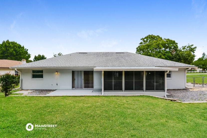 a white house with glass doors and a grassy yard
