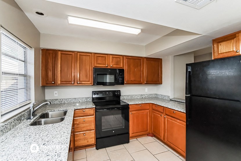 a kitchen with black appliances and granite counter tops