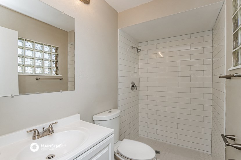 a bathroom with a toilet and a sink and a shower