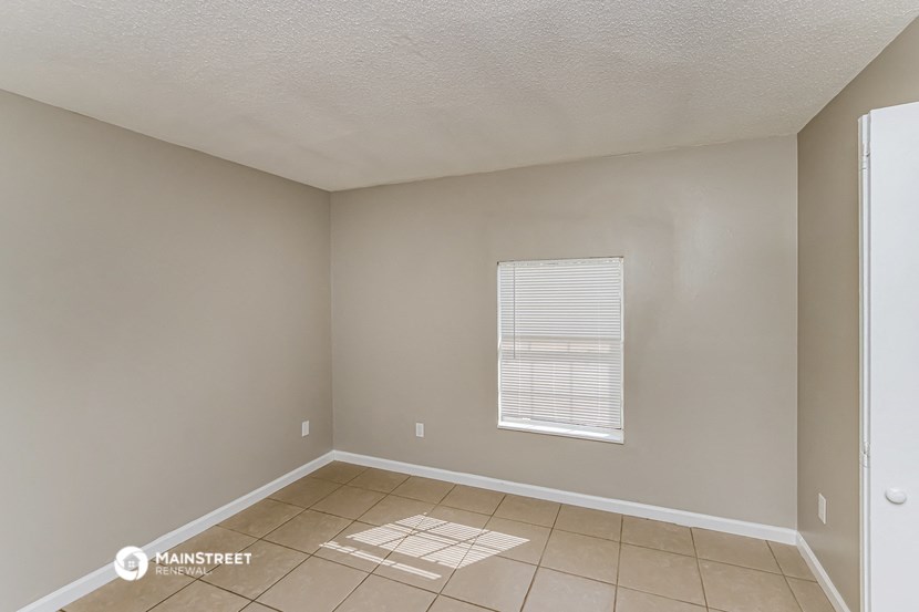 the living room of an empty house with a tiled floor
