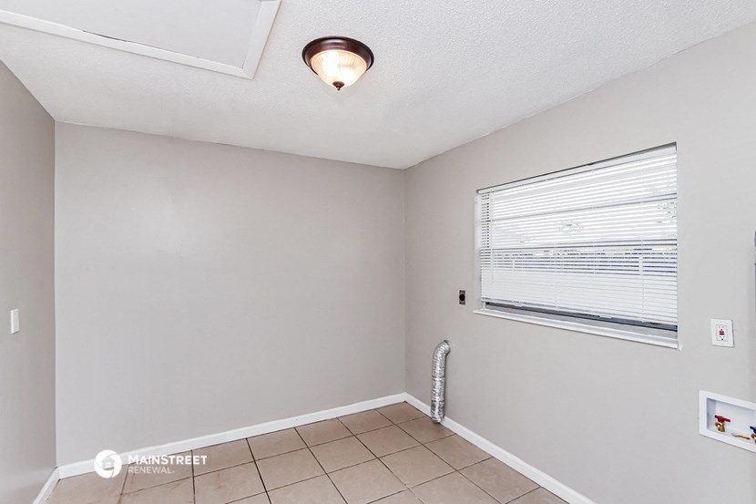 the living room has a large window and a tiled floor