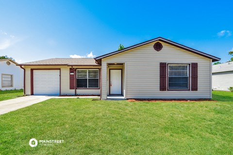 a white house with a lawn and a blue sky