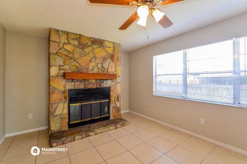 the living room has a stone fireplace and a large window