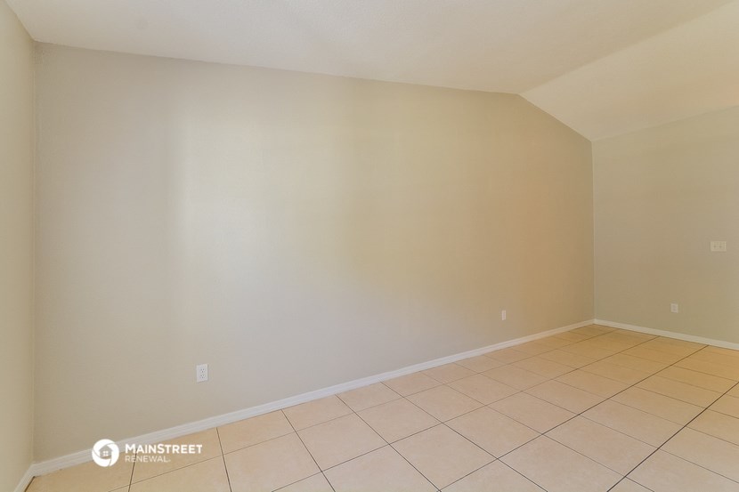 a empty room with a tiled floor and a white wall