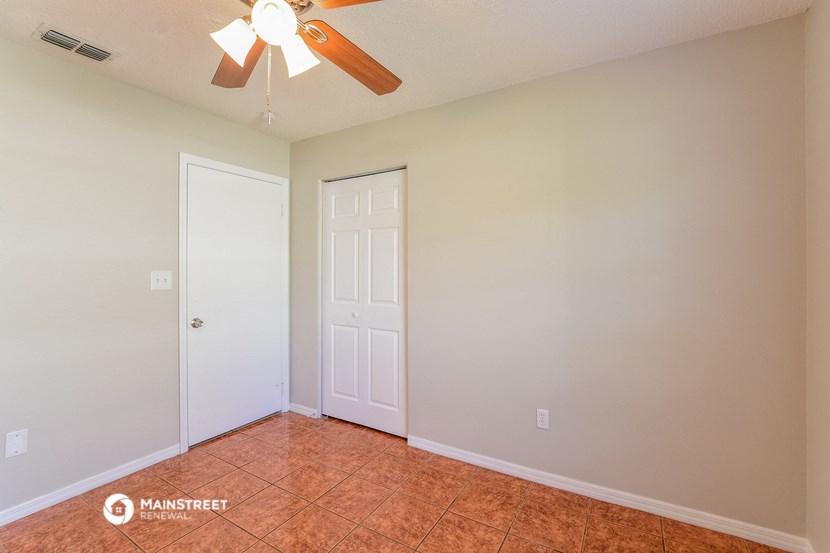 the living room of an empty house with a ceiling fan